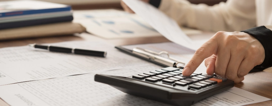 Senior father and his young son sitting on bench by lake in nature, talking.
