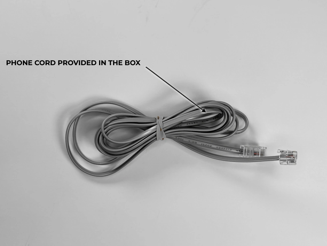 phone cord provided in the box with the medical alert with the arrow pointed at it