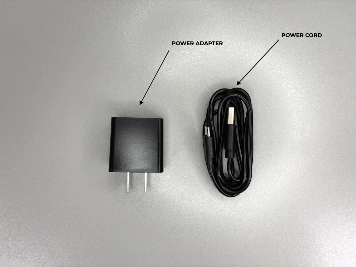holding a base unit in hand with arrows pointing at port labeled 'Wall', port labeled 'PHONE', reset button, and t/l button.