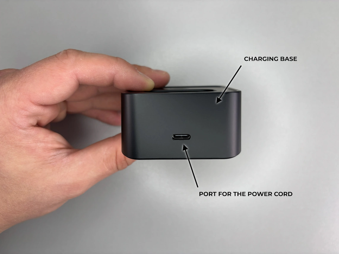 holding a base unit in hand with arrows pointing at port labeled 'Wall', port labeled 'PHONE', reset button, and t/l button.